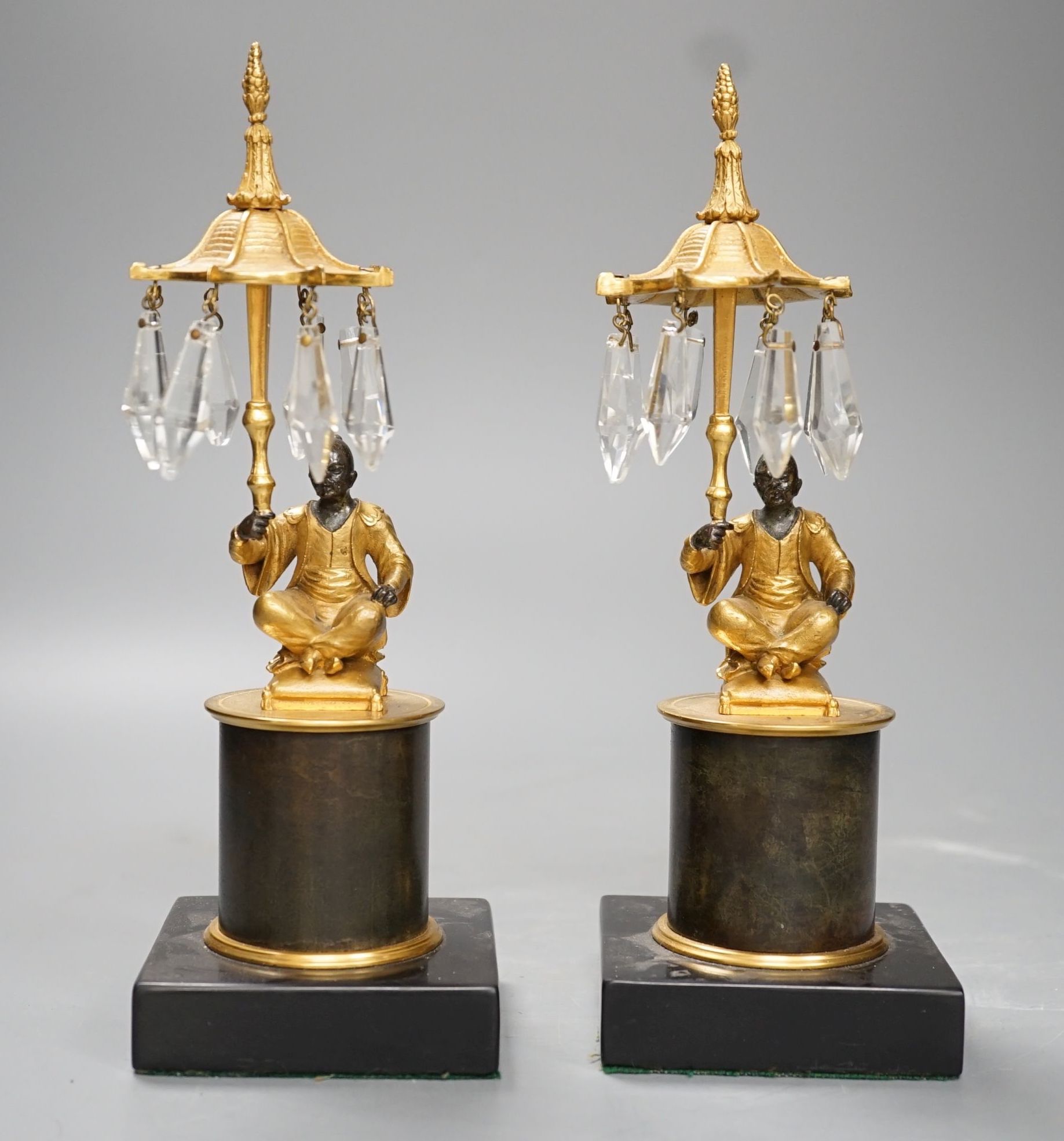 A pair of Louis XVI style bronze chinoiserie lustres depicted plinth seated gentleman bearing umbrella lustre drops - 23cm tall